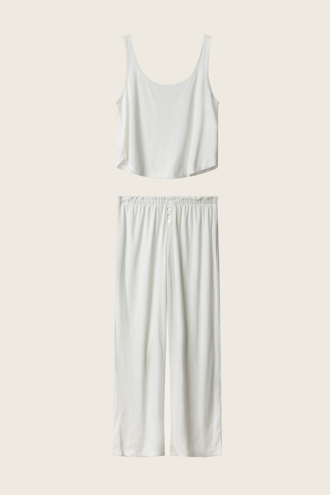 The Pointelle Essentials Ivory PJ Set by P.J. Salvage features a sleeveless cropped tank and wide-leg, elastic-waist pants, both in white, displayed on a cream background.