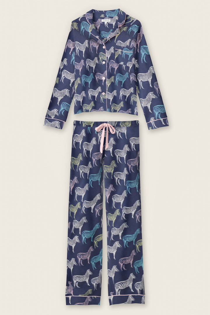 The Whimsy Technicolor Safari PJ Set by P.J. Salvage features a navy blue long-sleeve button-up top and pants, both decorated with a colorful zebra print and finished with a pink drawstring waist.