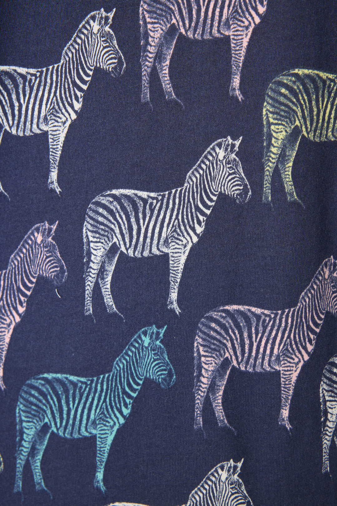 The Whimsy Technicolor Safari PJ Set by P.J. Salvage features a dark blue fabric patterned with multicolored zebras—white, yellow, blue, and pink—facing different directions for a playful look.