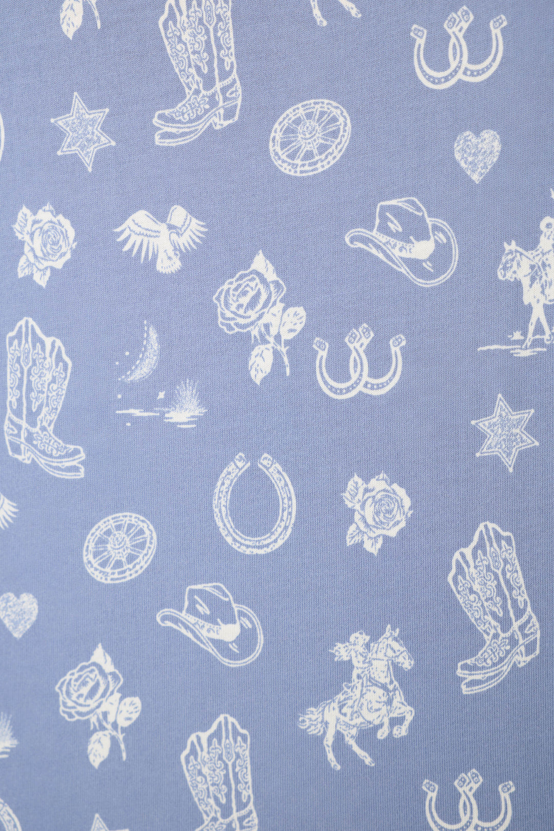 The Whimsy Lone Star Love Cropped PJ Set by P.J. Salvage features light purple fabric adorned with white Western-inspired prints, including cowboy boots, horseshoes, hats, roses, stars, a bird, horse and rider, lasso, heart, and campfire.