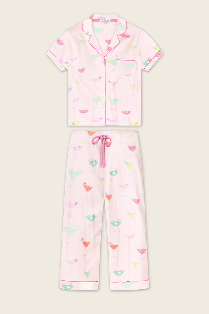 The Whimsy Sip Happens Cropped PJ Set by P.J. Salvage features a light pink short-sleeve button-up shirt and drawstring pants, both with colorful cocktail glass prints and pink piping.