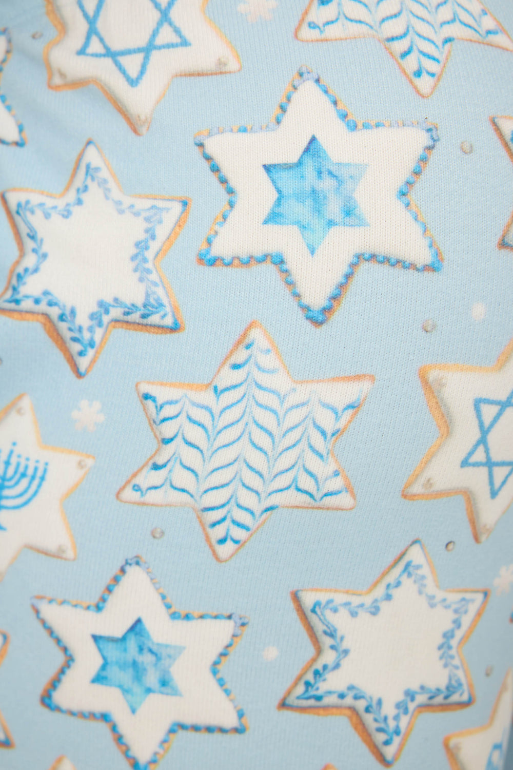 A close-up of P.J. Salvage’s HANUKKAH BANDED PANT YOU HAD ME AT SHALOM, featuring white and blue Hanukkah-themed designs like the Star of David and menorahs on a light blue background.