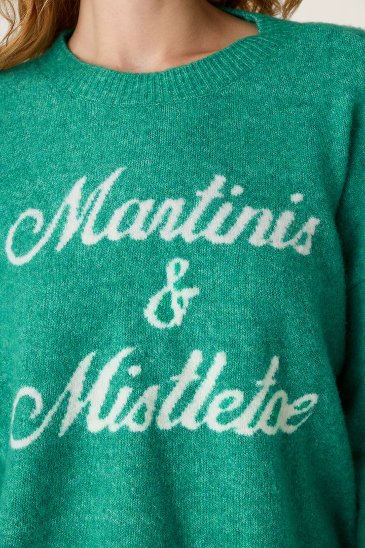 Cozy green Martinis & Mistletoe Snuggle Sweater knit with white cursive lettering.