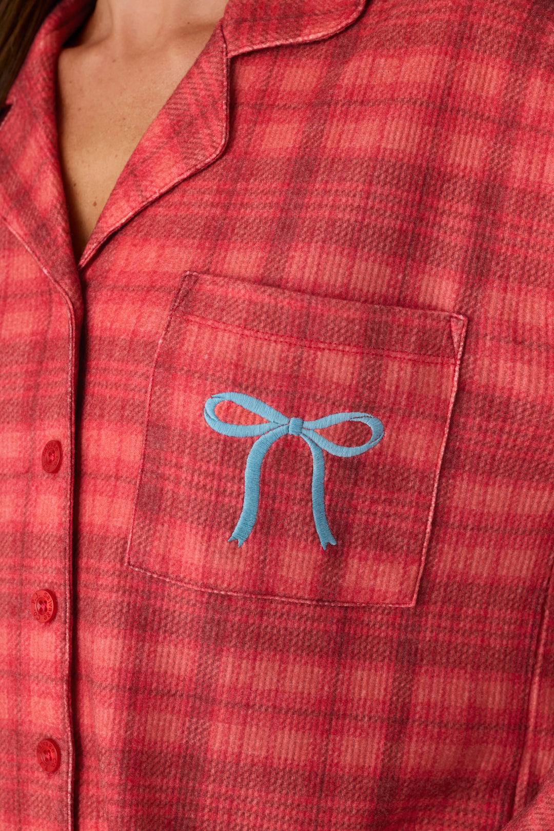 P.J. Salvage Mad for Plaid Long Sleeve Notch Collar Top in red plaid with a notched collar, button-up front, and a blue embroidered bow on the chest pocket.