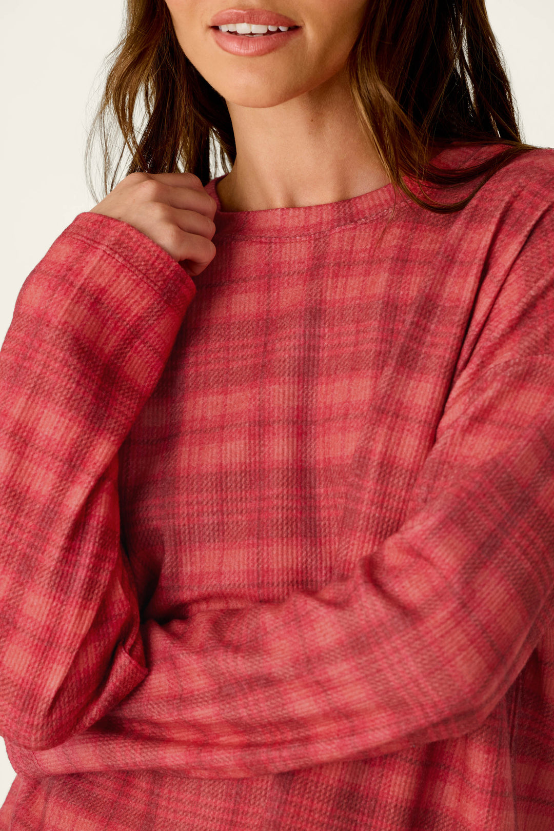 A person wearing a cozy red and dark pink plaid Mad for Plaid Long Sleeve Top.