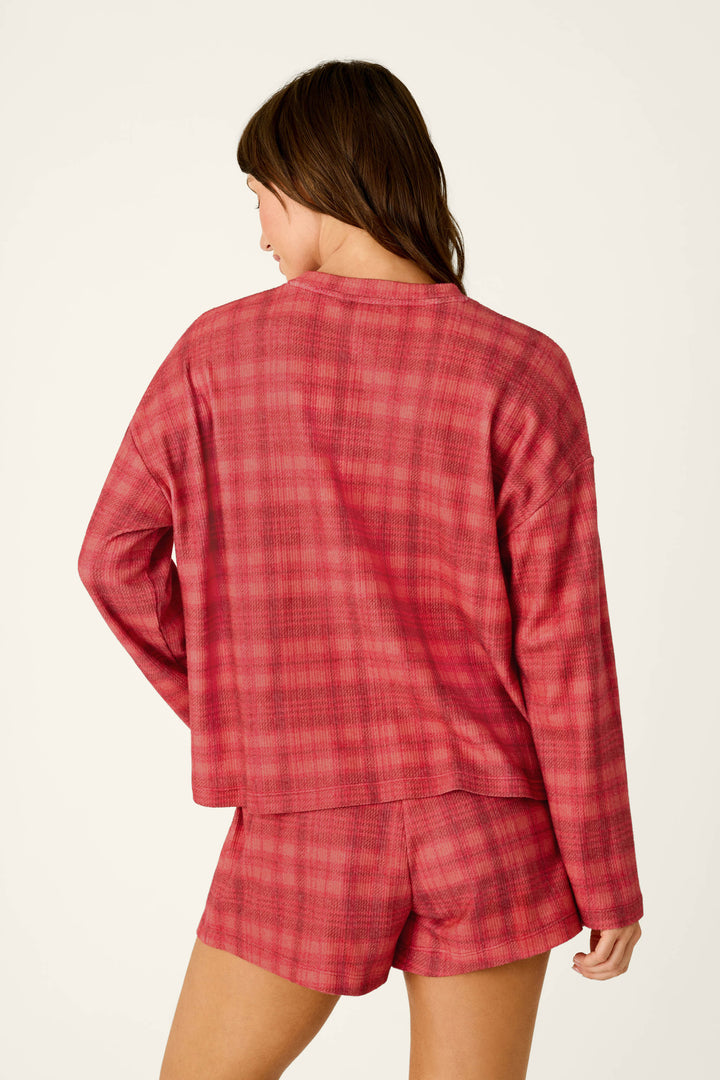 A woman viewed from behind wearing a red plaid Mad for Plaid Long Sleeve Top and matching shorts.