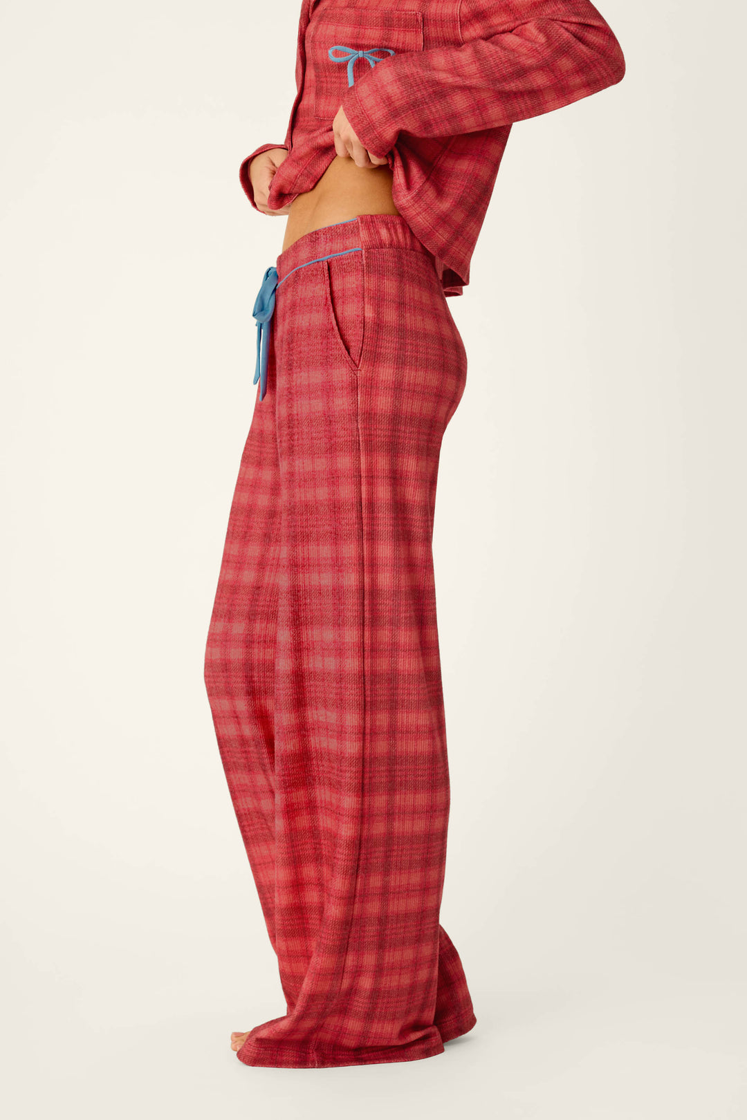 A person wearing a matching red plaid shirt and Mad for Plaid Pajama Pants with a blue drawstring waist.