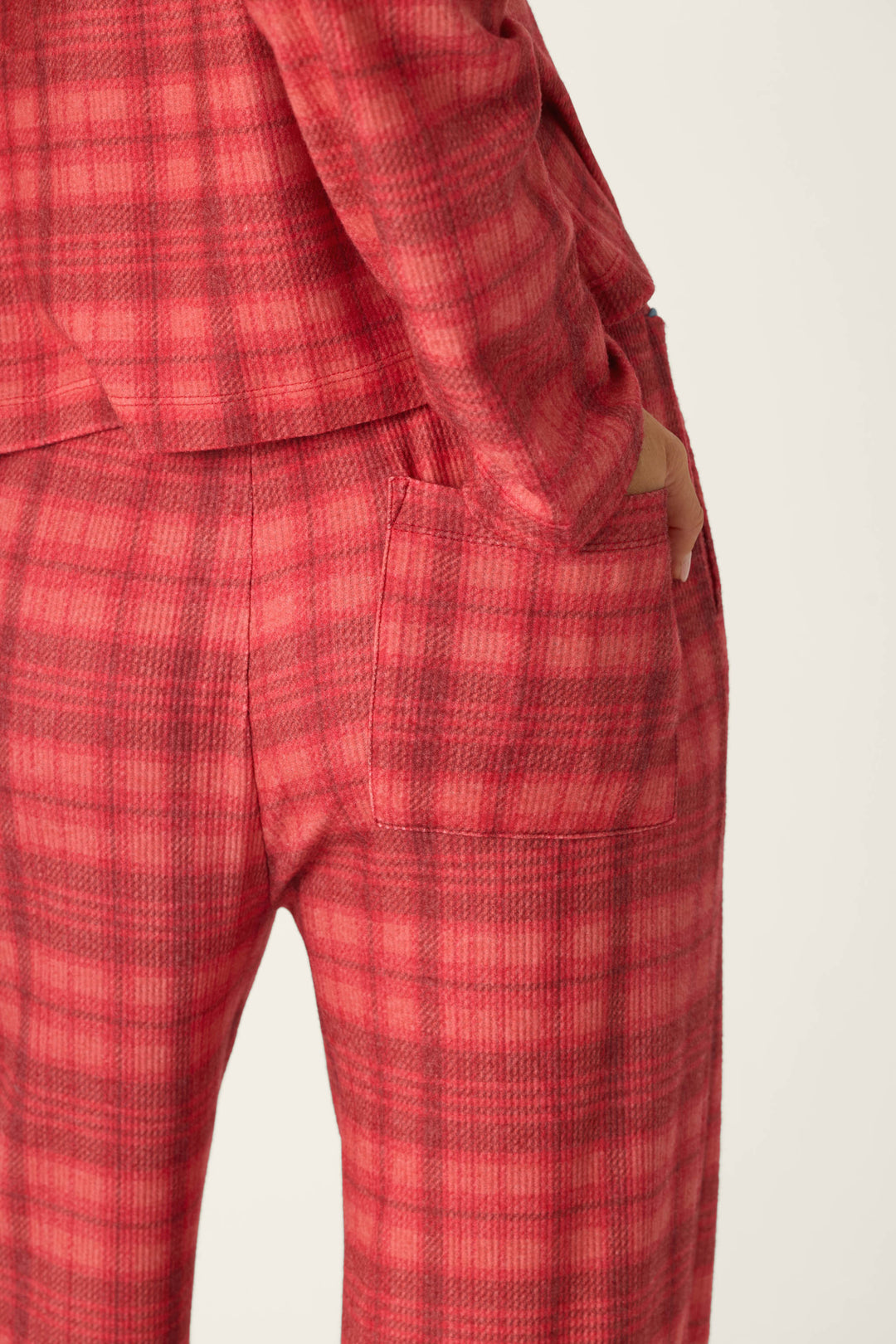 Mad for Plaid Pajama Pants by P.J. Salvage featuring red plaid pants with a back patch pocket and a matching long-sleeved top for cozy sleepwear.