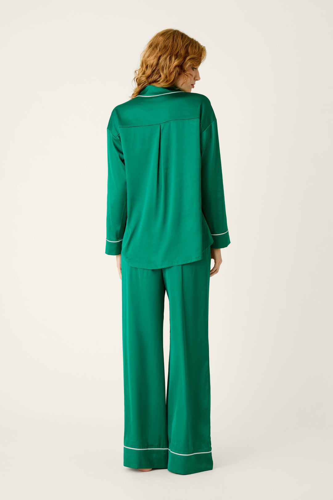 Back view of the P.J. Salvage Moonlight Muse Green Satin Long Sleeve PJ Set, featuring a green silky satin button-down top and matching wide-leg pants with white piping trim.
