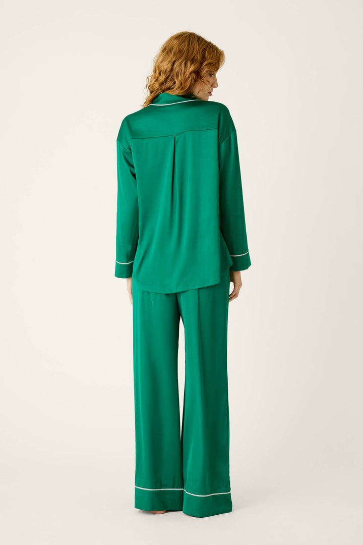 Back view of the P.J. Salvage Moonlight Muse Green Satin Long Sleeve PJ Set, featuring a green silky satin button-down top and matching wide-leg pants with white piping trim.