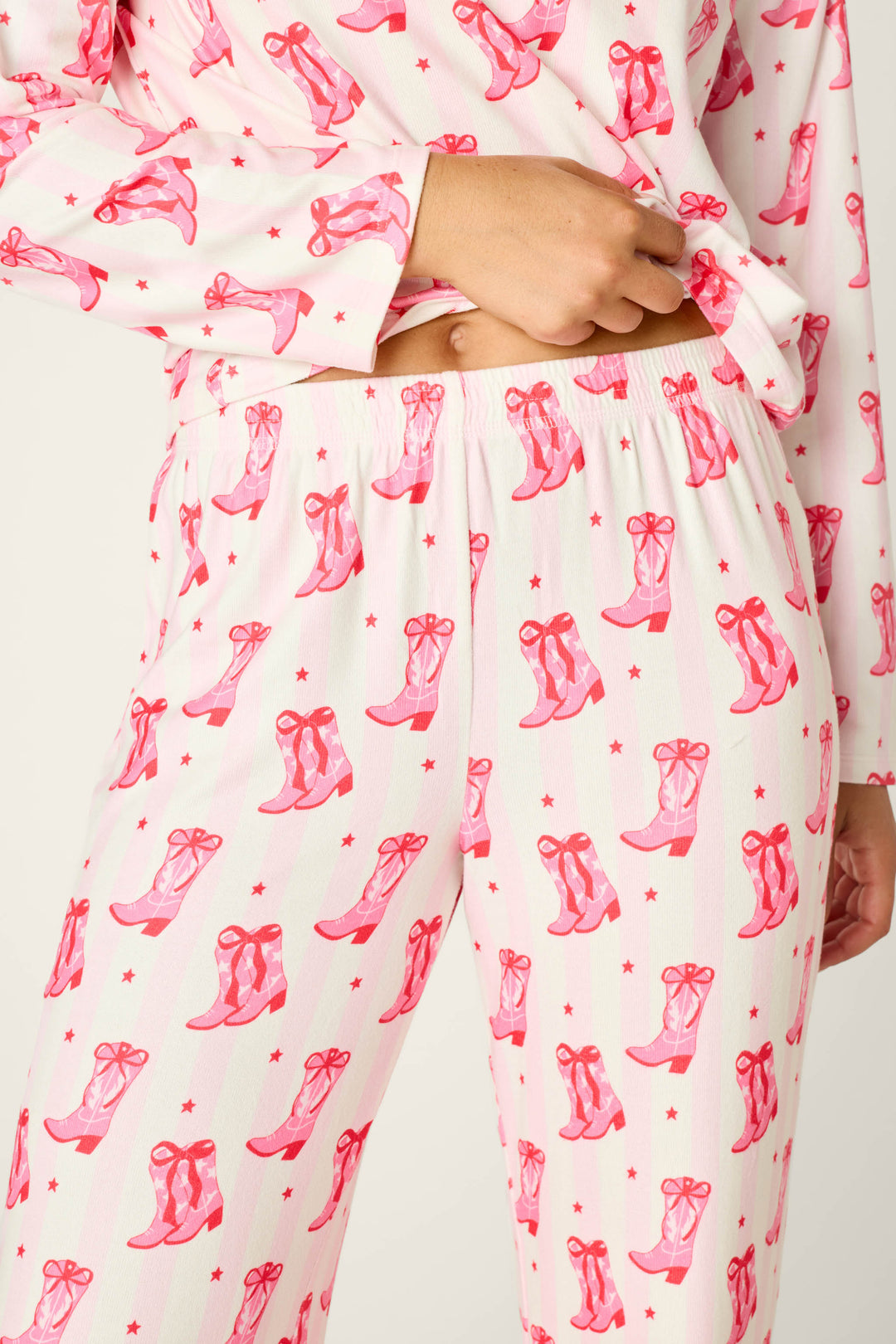 P.J. Salvage Midnight Rodeo Cowboy Boots & Stripe Print Long Sleeve PJ Set featuring a long-sleeve double-brushed pointelle top and matching pants with a pink stripe pattern and a repeating print of cowboy boots and small stars.