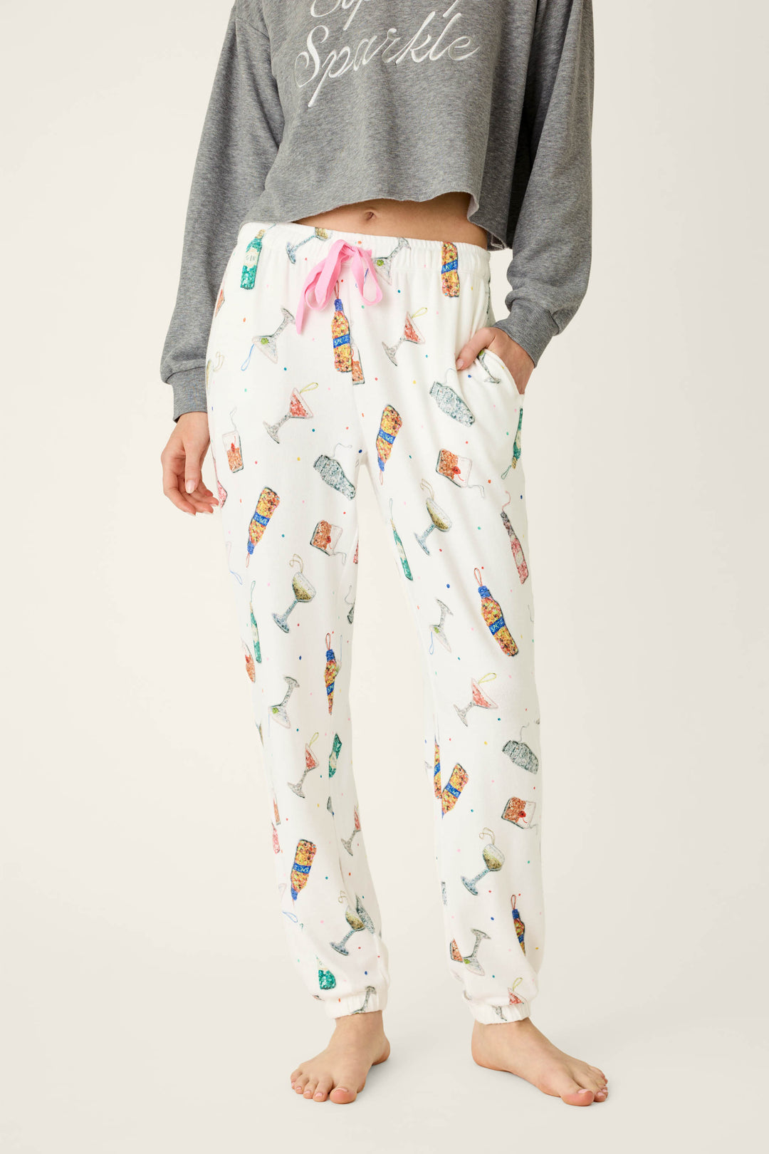 P.J. Salvage Sip Sip Sparkle Cocktail Charms Print Jogger Pant in peachy jersey featuring colorful cocktails and confetti on a white background with a pink drawstring waist.