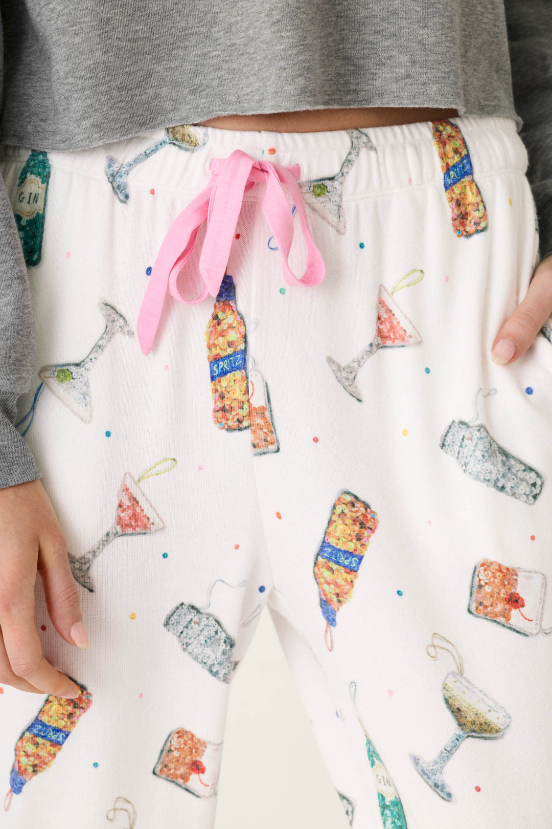 P.J. Salvage Sip Sip Sparkle Cocktail Charms Print Jogger Pant in white, peachy jersey featuring a colorful cocktail and bottle print with a pink drawstring at the waist.