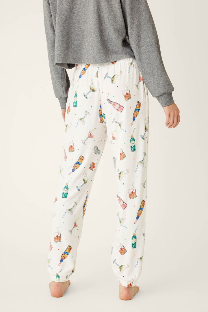 Person wearing Sip Sip Sparkle Cocktail Charms Print Jogger Pant in white paired with a grey sweatshirt.