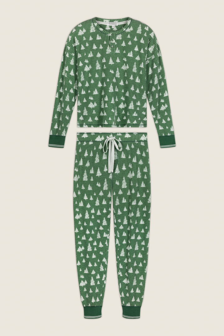 P.J. Salvage Ski Jammie Classics Tree Print Long Sleeve PJ Set consisting of a long sleeve shirt and matching green joggers with a white evergreen tree print and a white drawstring waist.