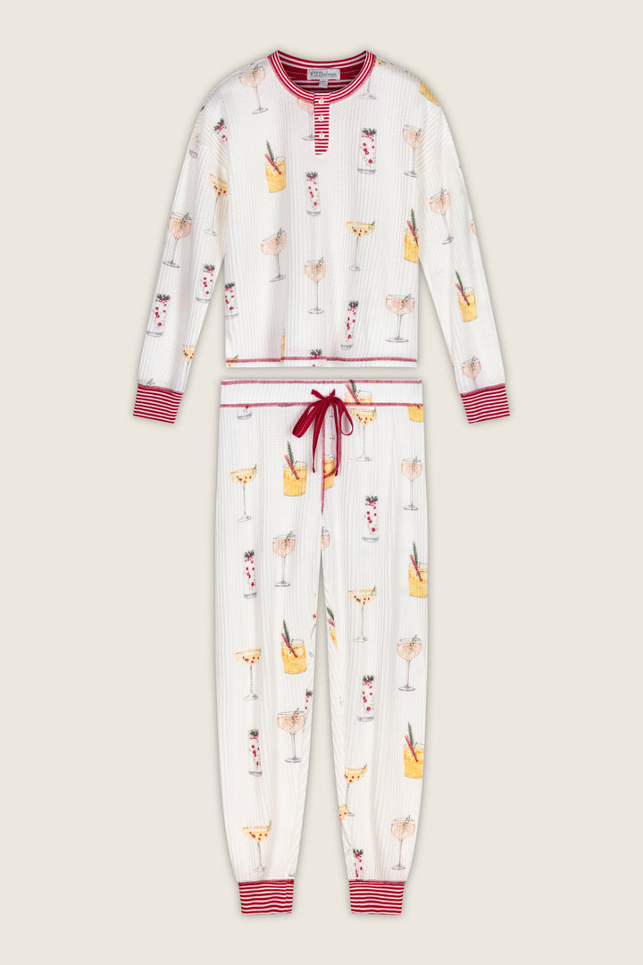 P.J. Salvage Ski Jammie Classics Cocktail Print Long Sleeve PJ Set featuring a long-sleeved henley top and matching jogger pants in an off-white waffle knit with a colorful cocktail print and red striped trim.