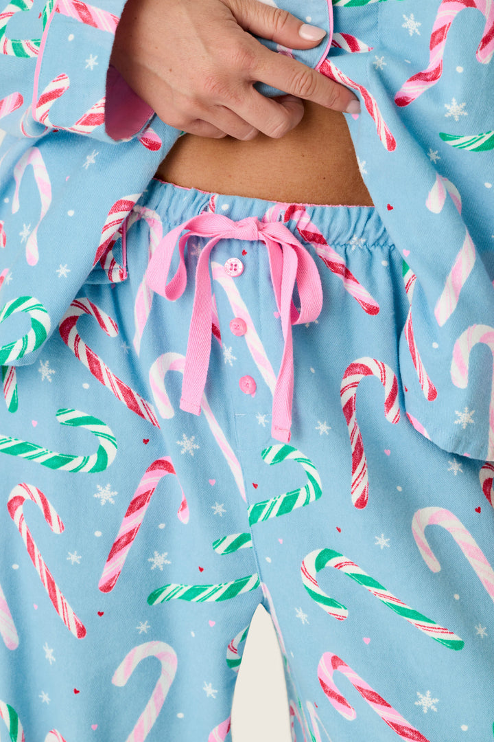 The Sweetest Season Candy Cane Print Flannel 3-Piece PJ Set in light blue with a candy cane and snowflake print, featuring a pink drawstring waist.