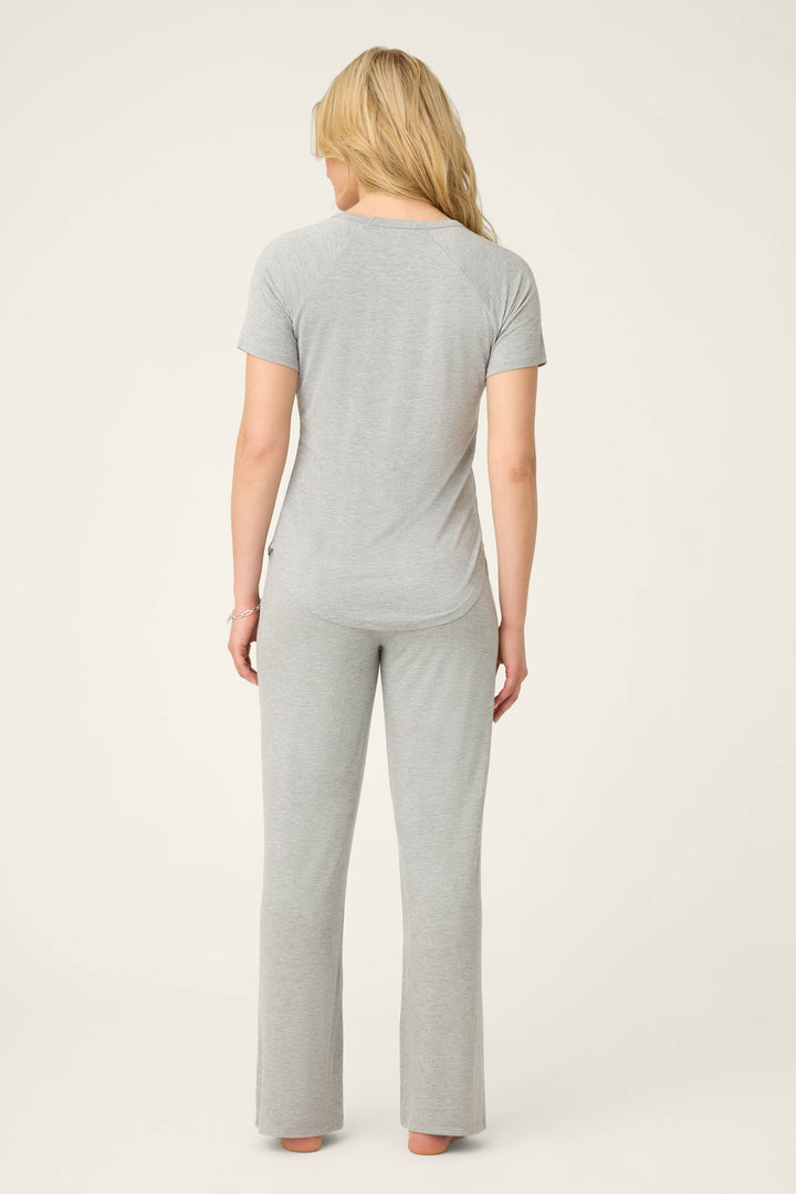 A person with long blonde hair stands barefoot, facing away from the camera, wearing the P.J. Salvage Modal Basics Heather Grey PJ Set against a plain light background.
