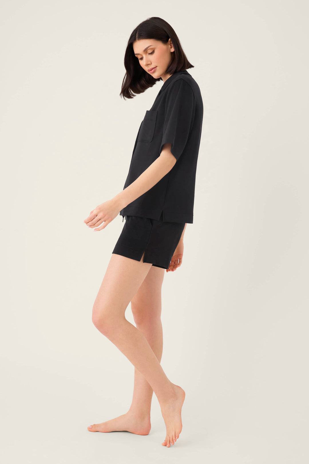 A woman in the P.J. Salvage Jammie Essentials Short Black PJ Set with a notch collar top exudes effortless style and comfort.