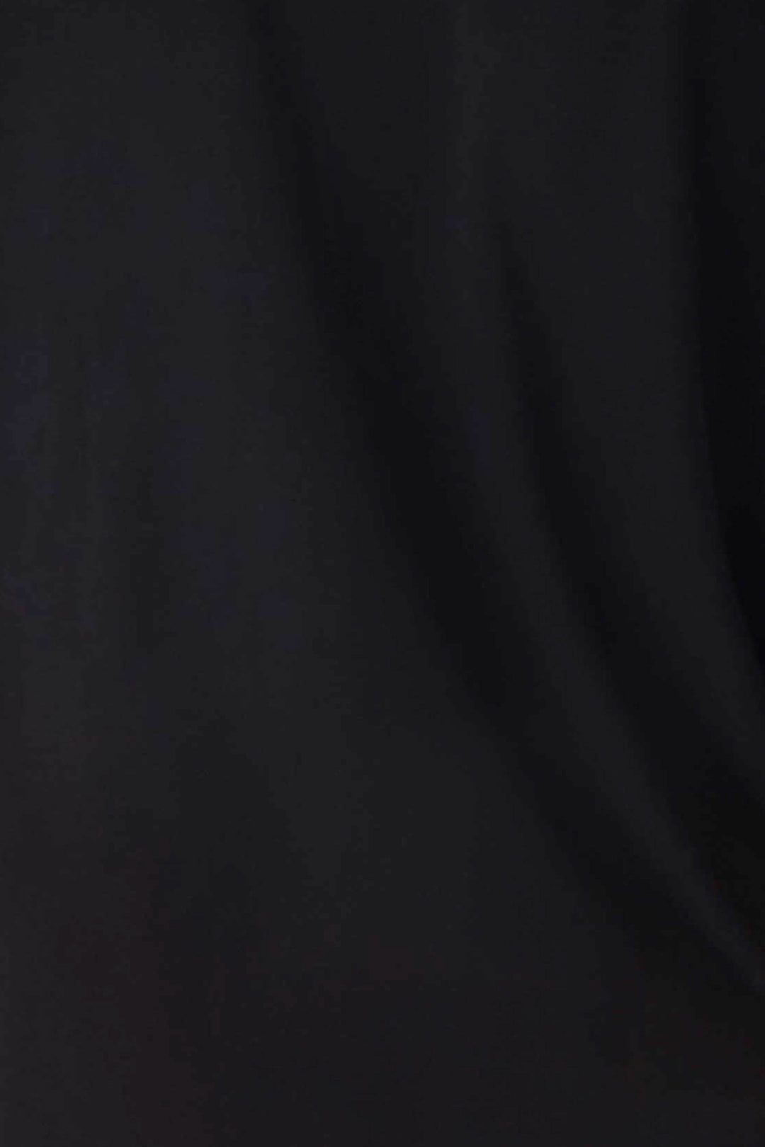 A close-up of the black fabric from the Jammie Essentials Short Black PJ Set by P.J. Salvage shows subtle folds and soft shadows, highlighting slight texture variations.