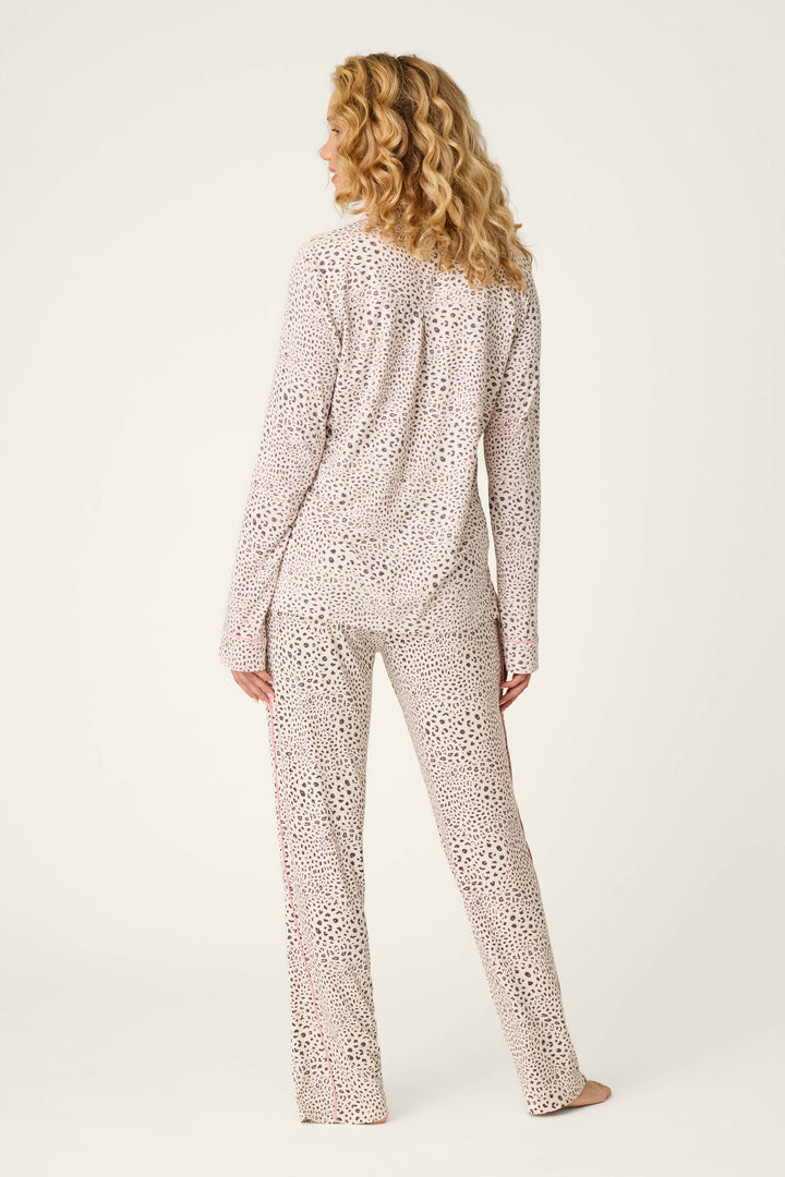 A woman with curly blonde hair stands barefoot, facing away from the camera, wearing the P.J. Salvage Modal Dreams Leopard Print 3-Piece PJ Set featuring a light background with a subtle dark leopard pattern.