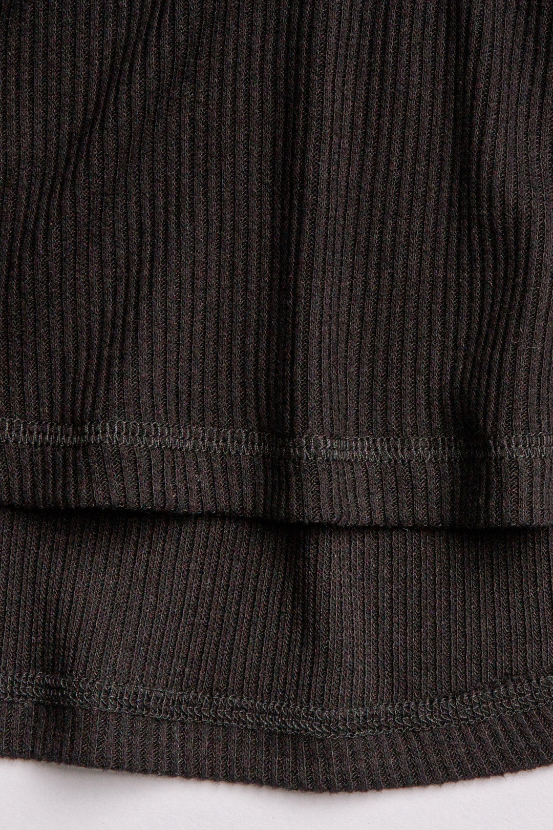 Black V-neck top with relaxed fit in 2x2 peachy rib. Banded sleeve cuff & neck rib. (7122611535972)