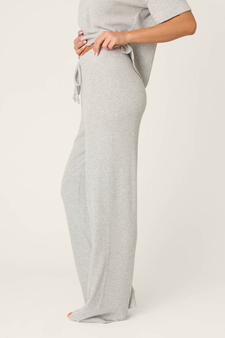 Model showcases the P.J. Salvage Textured Essentials Heather Grey Open Leg Pants, standing barefoot in a side profile against a plain background, wearing loose-fitting ribbed pants and a matching top, shown from shoulders down.