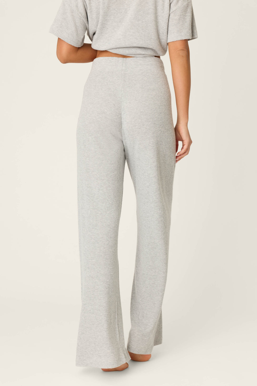 A person faces away from the camera, wearing P.J. Salvage Textured Essentials Heather Grey Open Leg Pants with a matching short-sleeve top. The relaxed outfit stands out against a plain off-white background.
