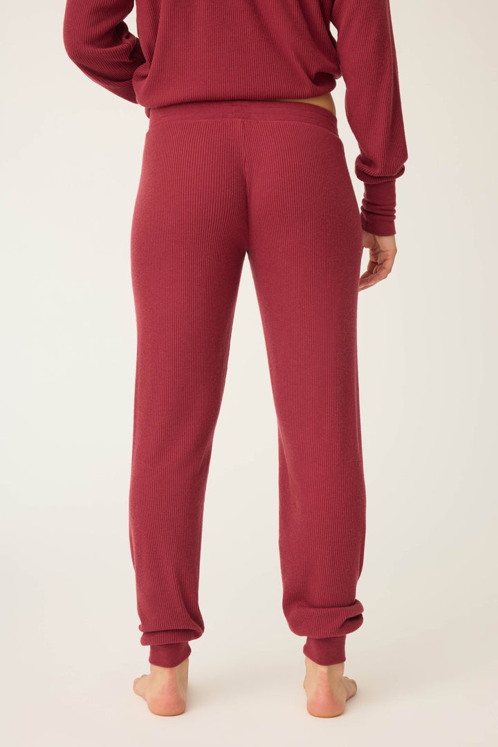 A person is shown from the back, barefoot, wearing P.J. Salvage Textured Essentials Banded Pants in Port, paired with a matching long-sleeve top, against a plain white background.