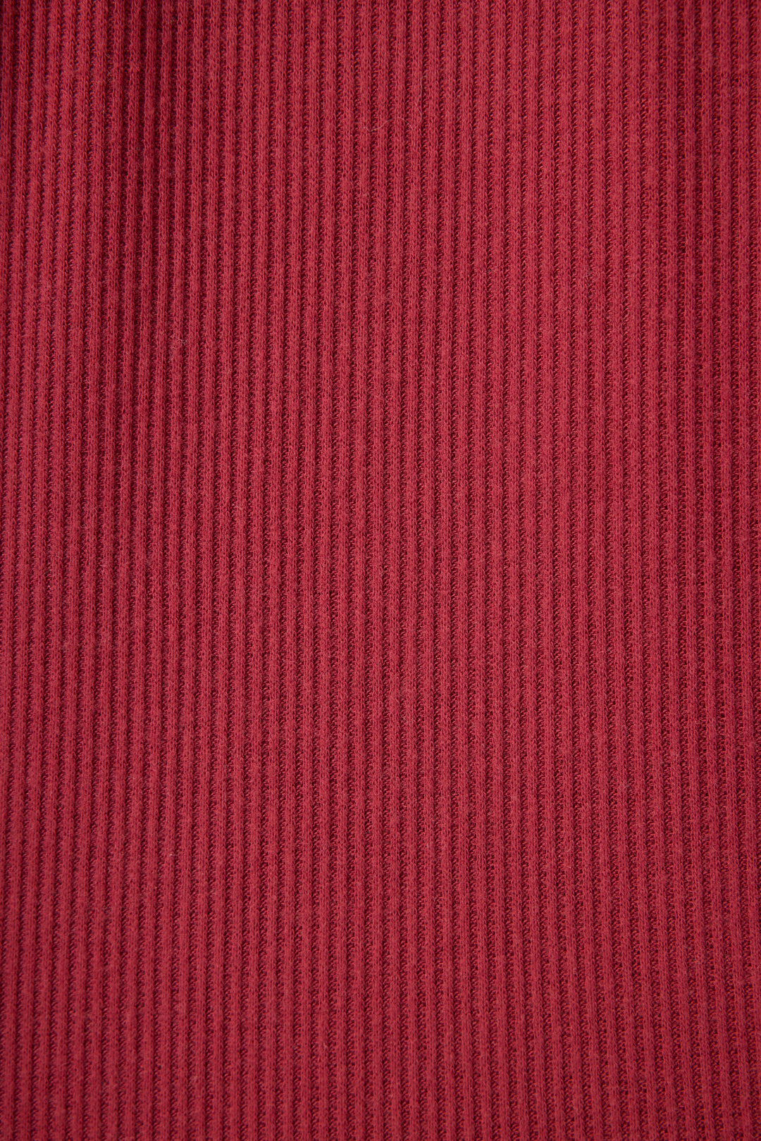 Close-up of P.J. Salvage Textured Essentials Banded Pants in Port, showing the soft red ribbed fabric with evenly spaced vertical textured lines across the surface.