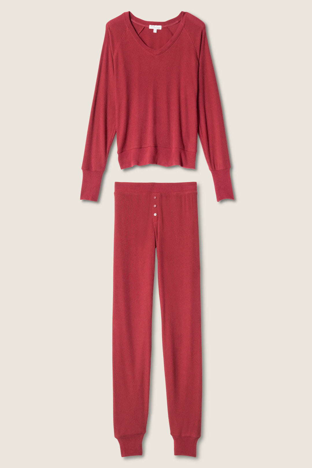 The P.J. Salvage Textured Essentials PJ Set—red long-sleeve V-neck top and long pants with a button fly—is displayed flat on a light background.