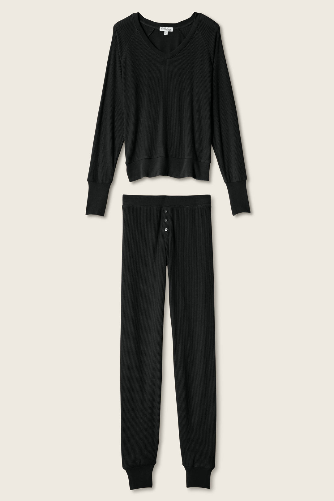 The P.J. Salvage Textured Essentials Black Long PJ Set features a soft ribbed peachy jersey V-neck top and button-fly lounge pants, shown against a light beige background.