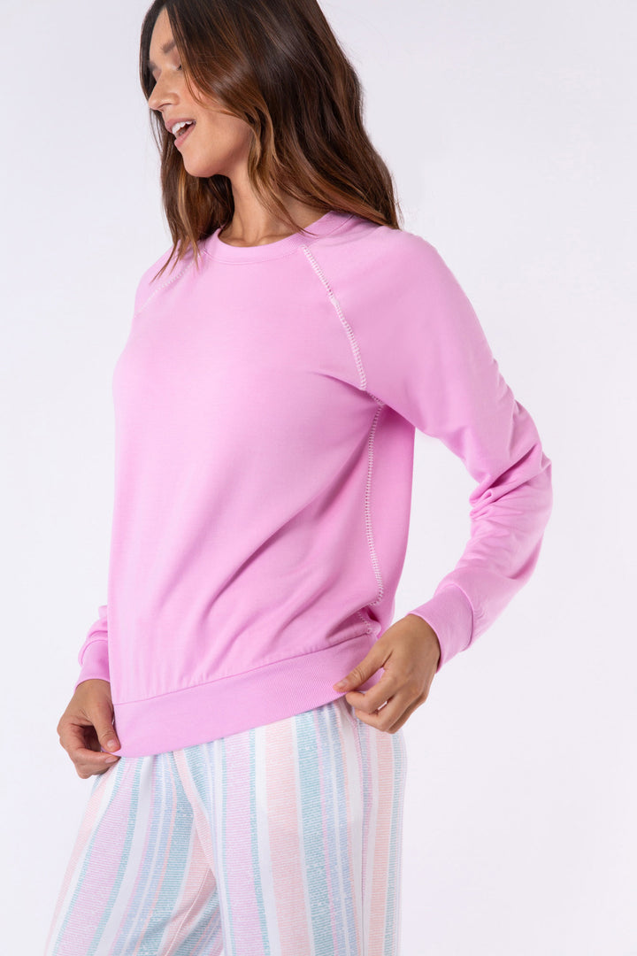 Pastel pink long sleeve top with white whipstitching at raglan seams. B&ed hem.