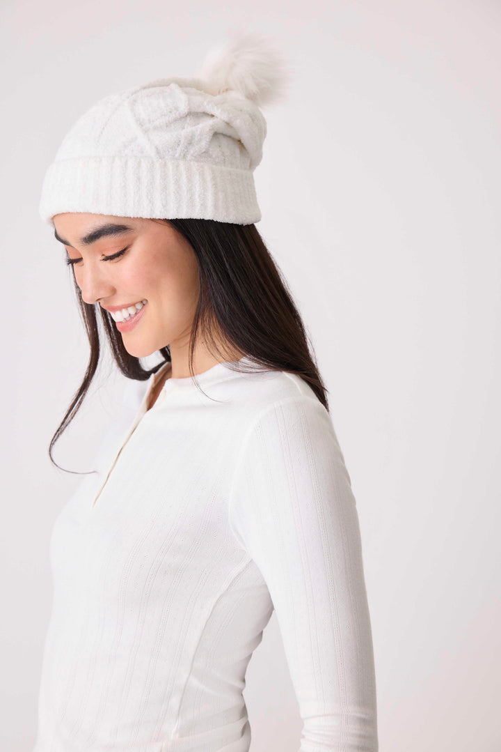 Women's cable texture knit beanie in ivory with pom pom on top.
