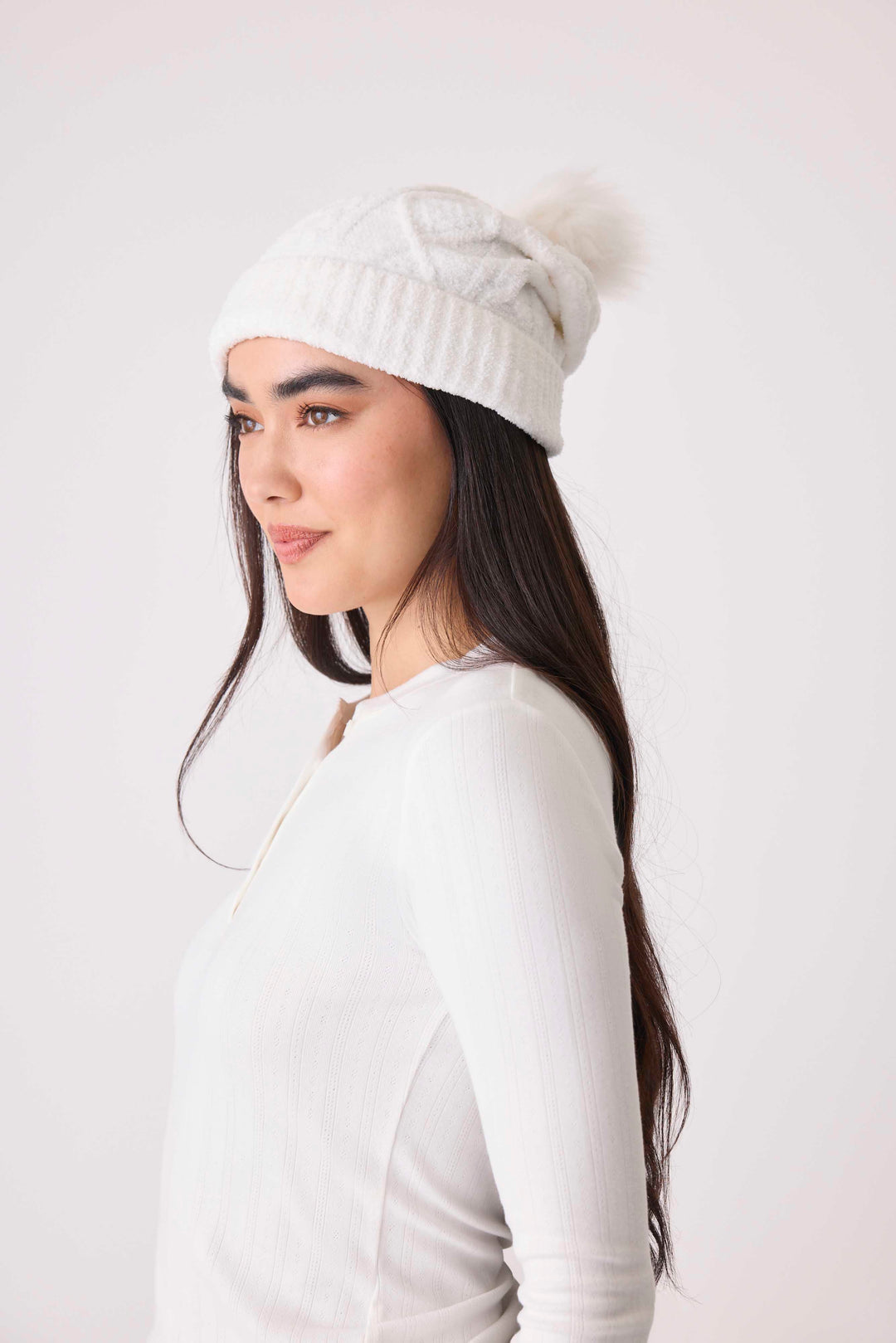 Women's cable texture knit beanie in ivory with pom pom on top.