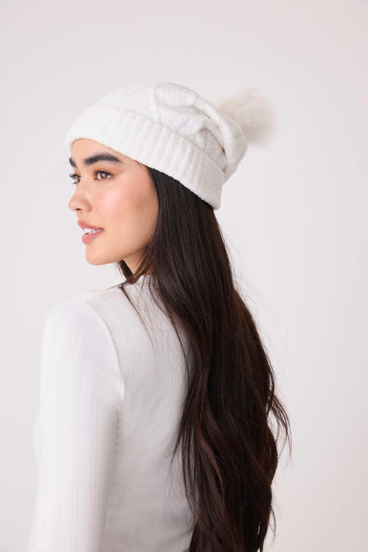 Women's cable texture knit beanie in ivory with pom pom on top.