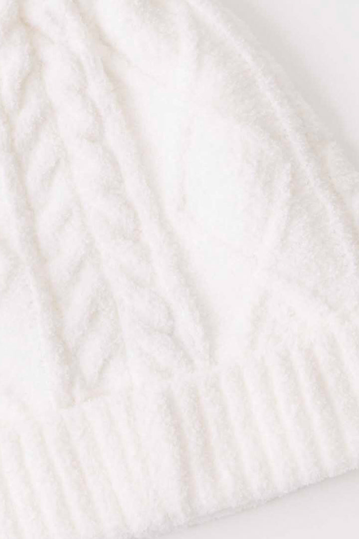 Women's cable texture knit beanie in ivory with pom pom on top.