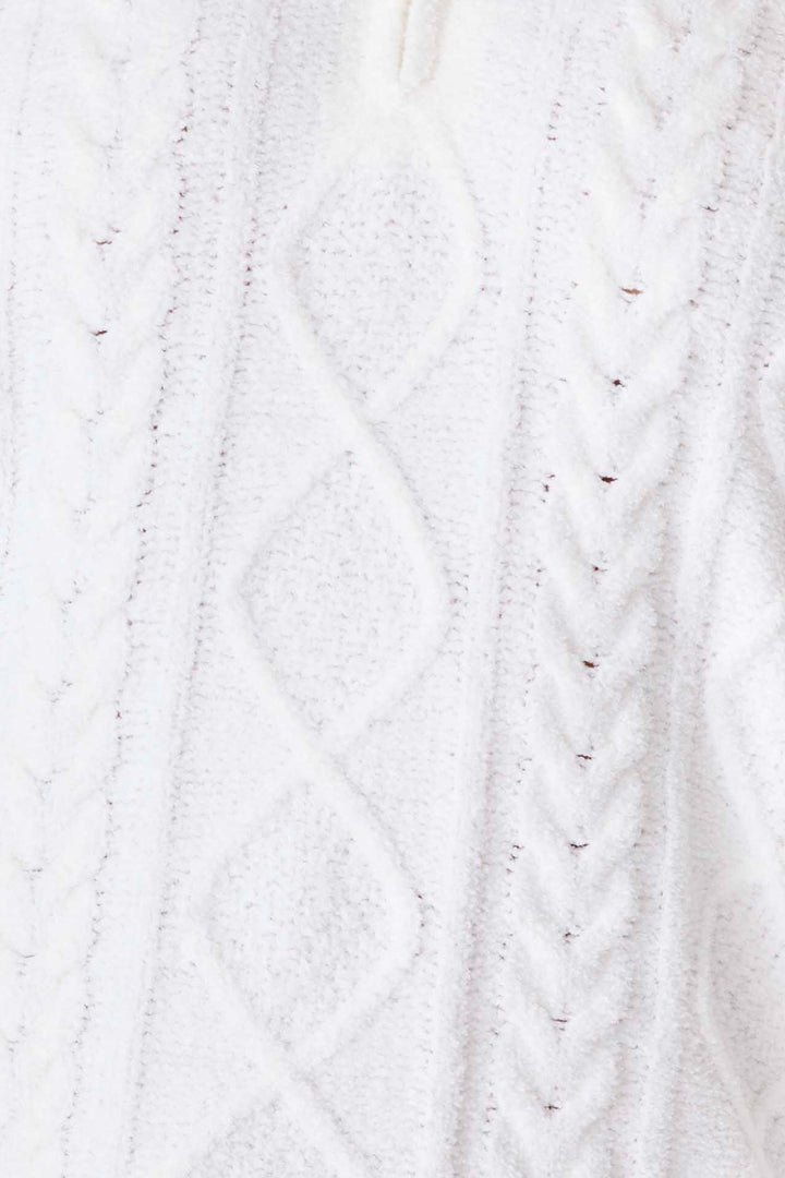 Close-up of the Chenille Cozy Cable Slippers by P.J. Salvage, showing soft white knit fabric with diamond and braided cable patterns.