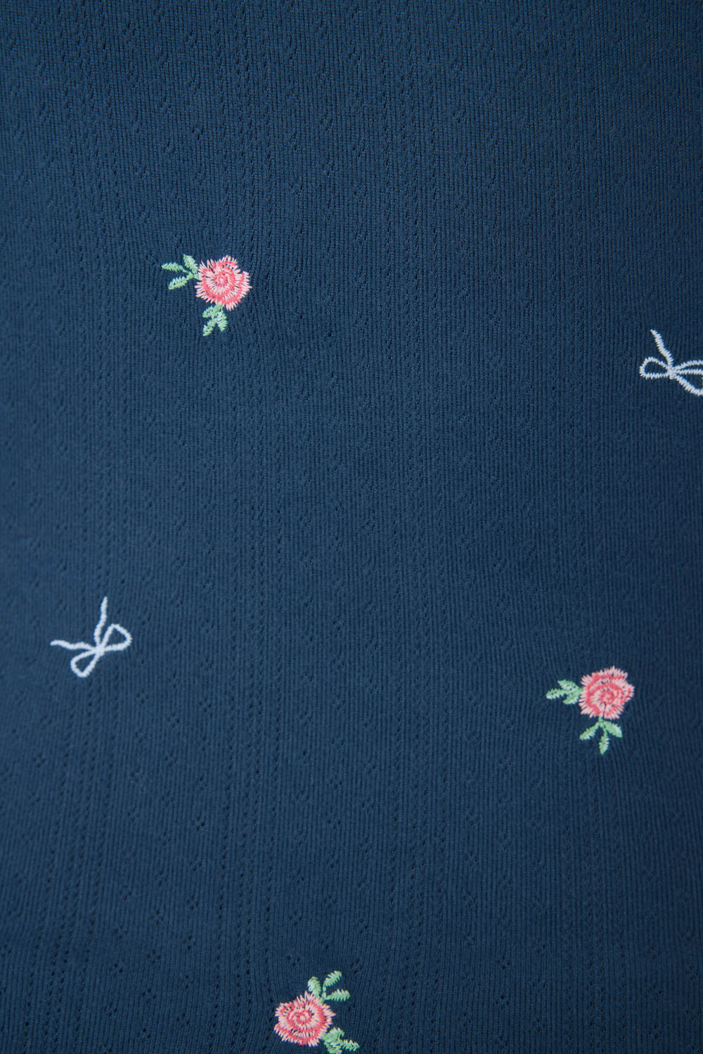 Navy blue floral camisole top for women with adjustable straps, picot edging, shelf bra, and curly hem.