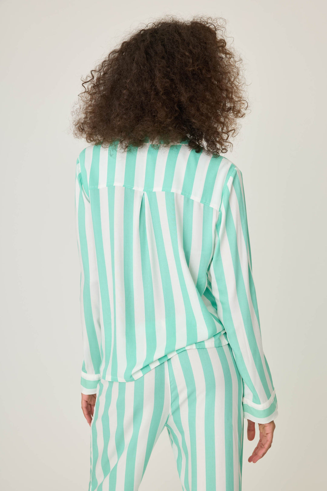 Long sleeve women's pajama top in ivory-green stripes in woven rayon sateen. Button-front wtih chest pocket & contrast striped cuffs.