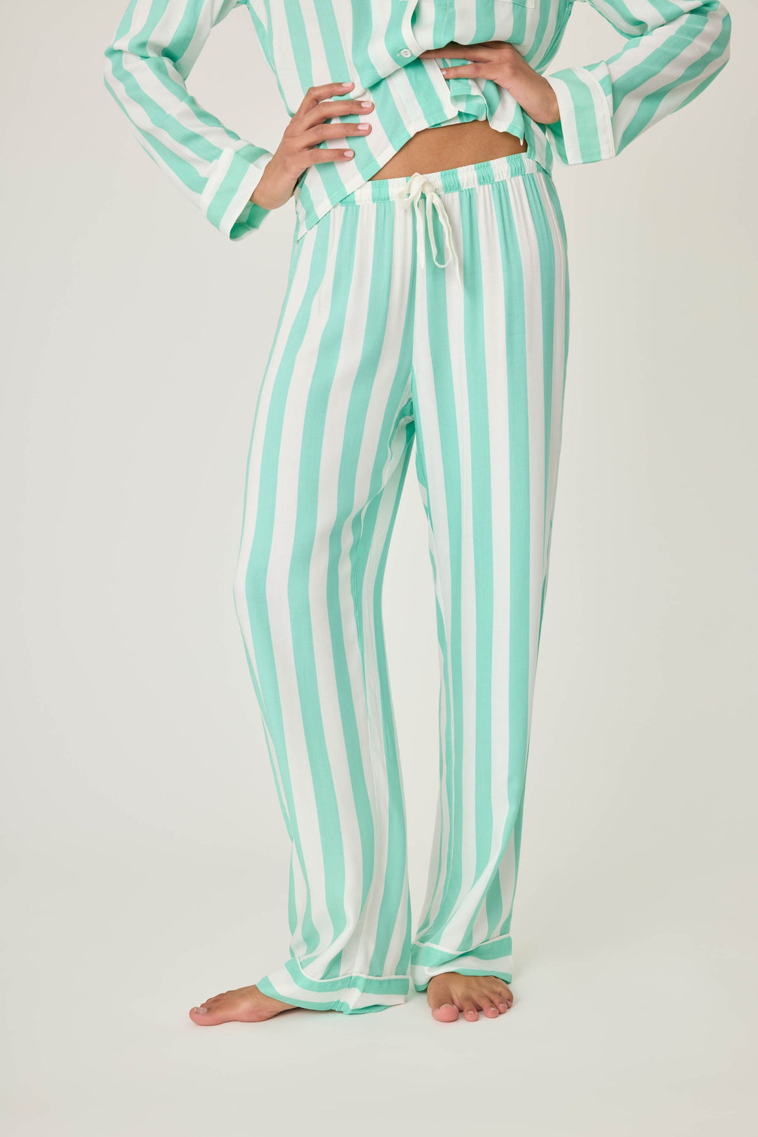 Women's pajama pant in ivory-green stripe print in woven rayon sateen. Tie-waist and contrast striped cuffs.