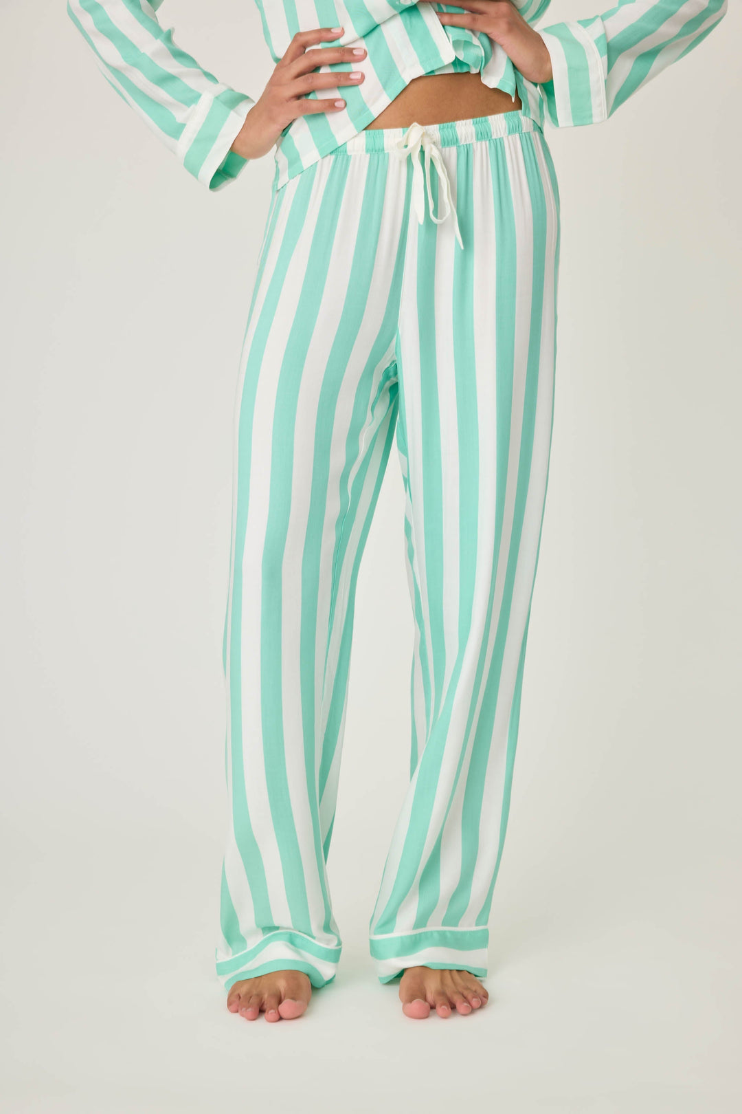Women's pajama pant in ivory-green stripe print in woven rayon sateen. Tie-waist and contrast striped cuffs.