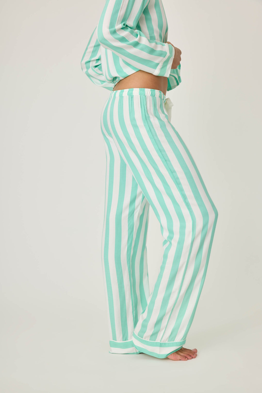 Women's pajama pant in ivory-green stripe print in woven rayon sateen. Tie-waist and contrast striped cuffs.