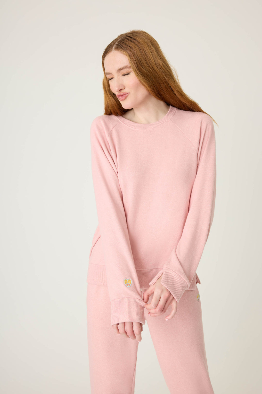 Women's longsleeve pink melange lounge top with small heart embroidery on cuff.