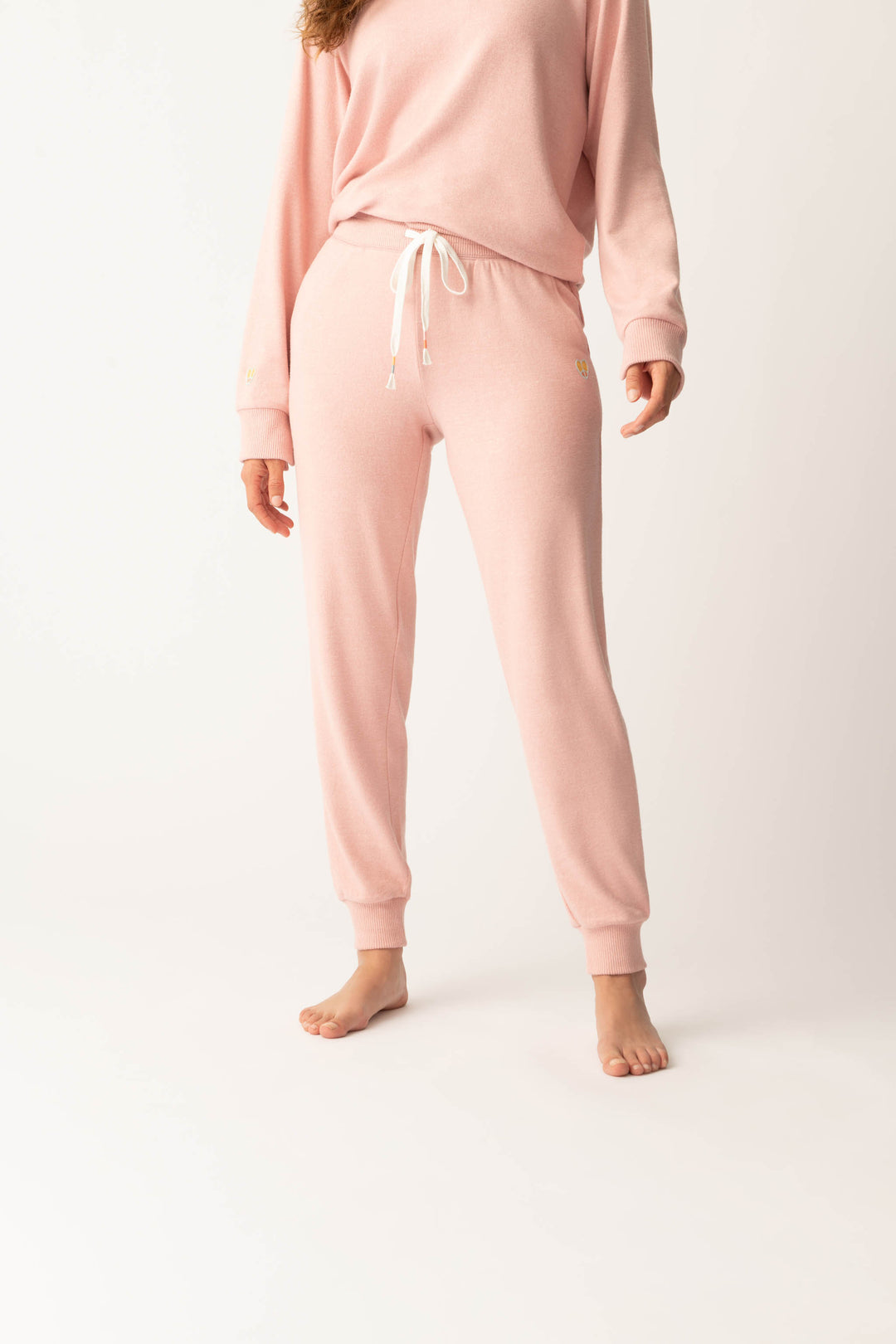 Women's pink melange jogger pant with small heart embroidery on cuff.