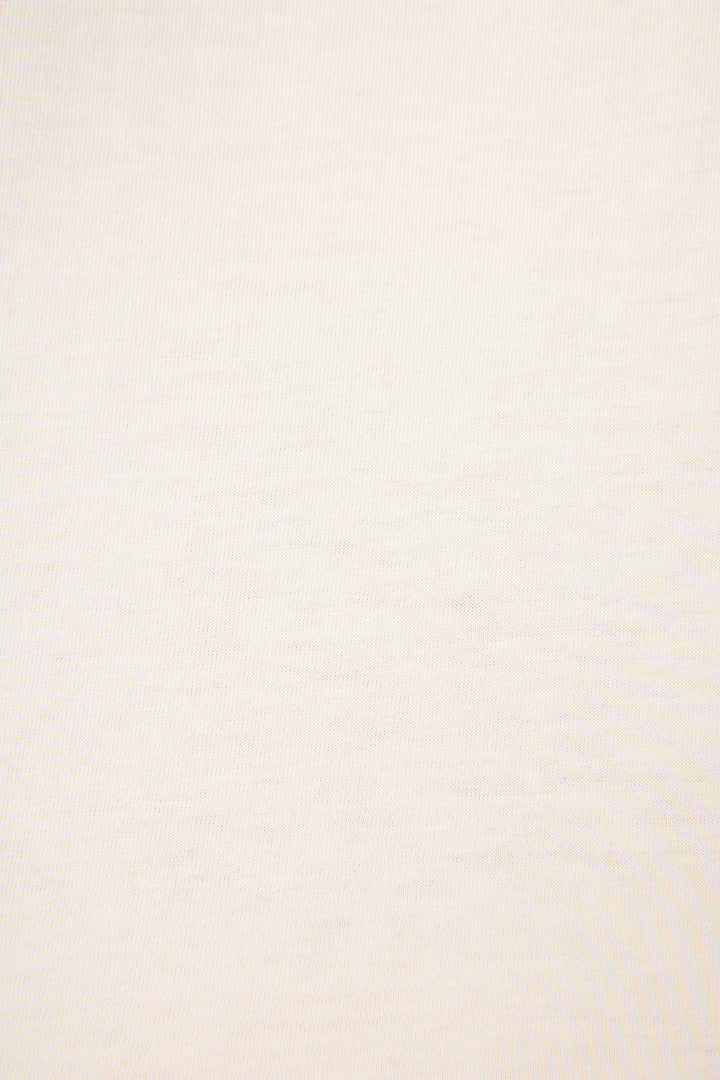 Close-up fabric swatch showing soft ivory knit texture of cotton-blend material.
