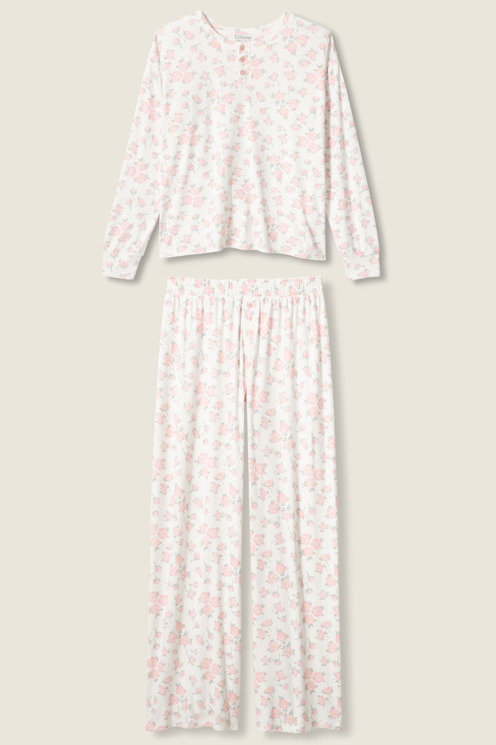 The P.J. Salvage Ivory Floral Print Henley PJ Set features a long-sleeve top with a round neckline and buttons, and full-length pants, both in white with a light pink floral pattern.