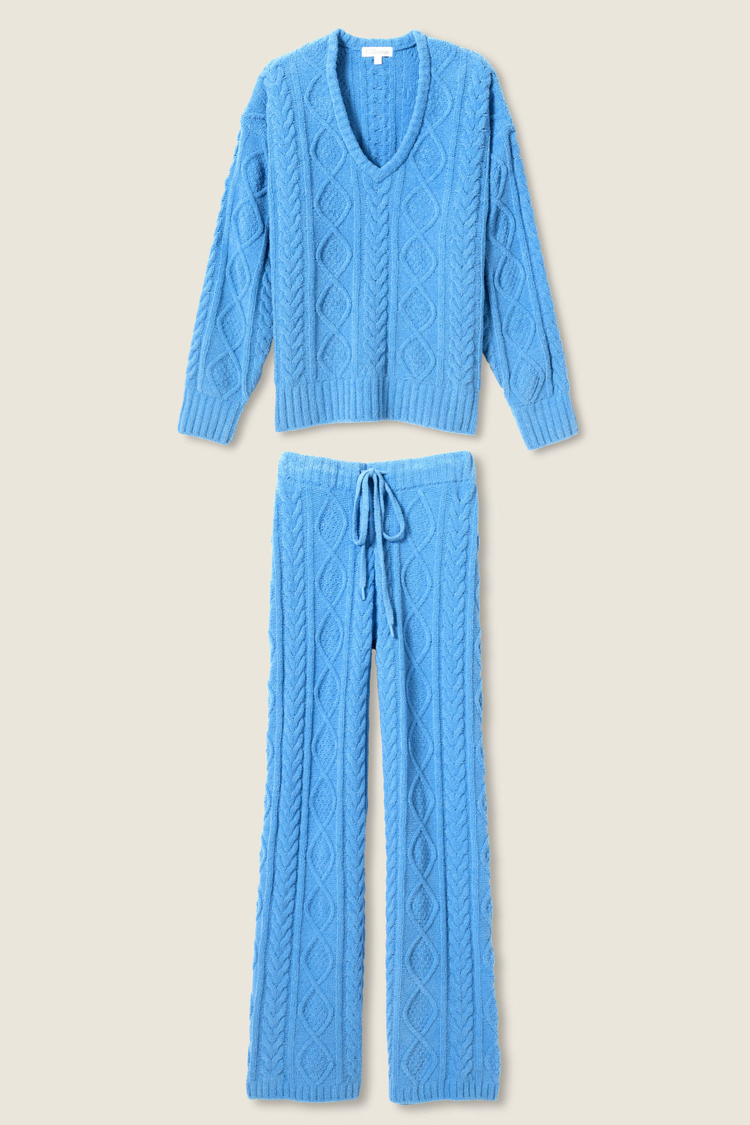 The SOLID PJ SET COZY CHENILLE CABLE KNIT by P.J. Salvage features a blue V-neck cable knit sweater with long sleeves and matching drawstring pants, both displayed flat on a light background.