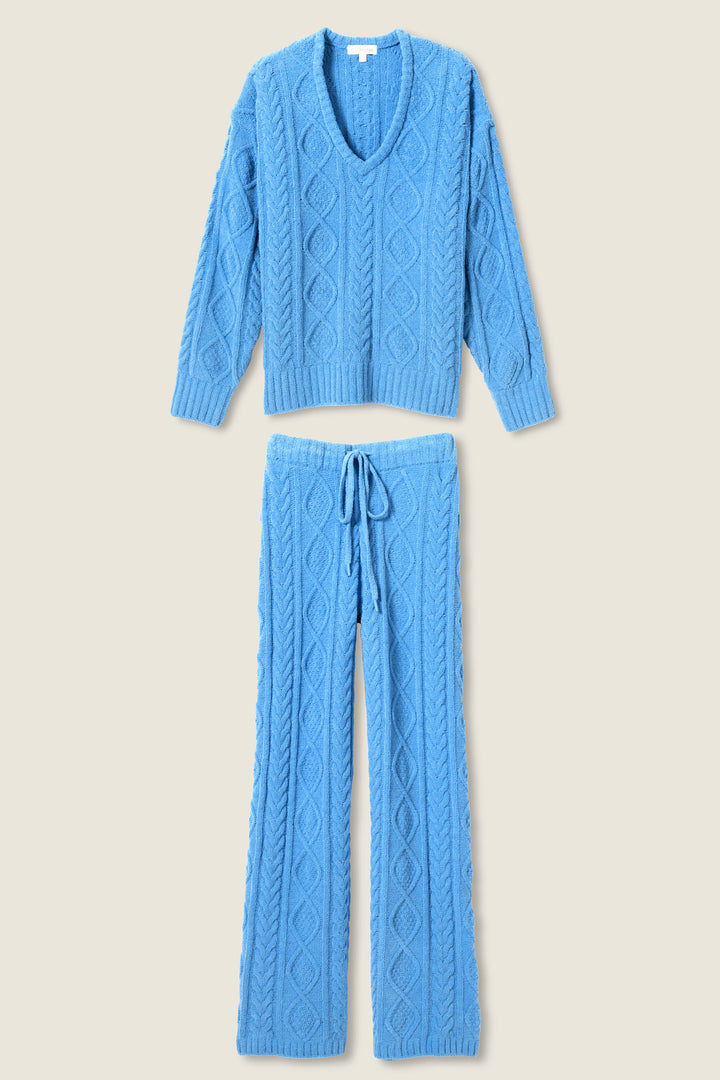 The SOLID PJ SET COZY CHENILLE CABLE KNIT by P.J. Salvage features a blue V-neck cable knit sweater with long sleeves and matching drawstring pants, both displayed flat on a light background.