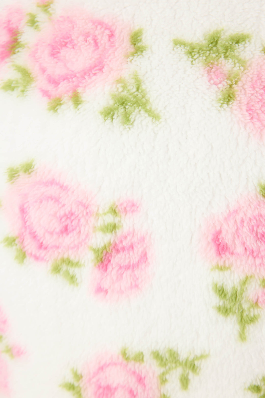 A close-up of the Lets Get Cozy Floral Print Robe by P.J. Salvage shows soft, white, fuzzy fabric with a delicate print of pink roses and green leaves, creating a cozy and gentle look.